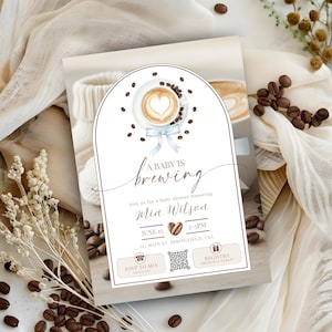 Peut inclure: Invitation de baby shower sur le thème du café. Le design présente une tasse de café latte art, des grains de café et le texte "A Baby Is Brewing". L'invitation comprend les détails de la baby shower de Mia Wilson.