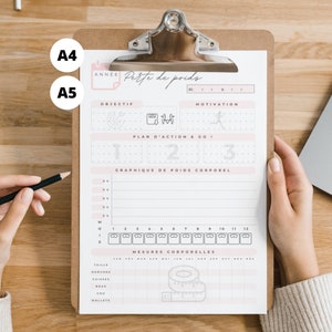 Peut inclure: Un tracker de perte de poids imprimable avec des sections pour la définition d'objectifs, la motivation, un tableau de suivi du poids et des mesures corporelles. Le tracker est sur un presse-papiers avec un crayon.