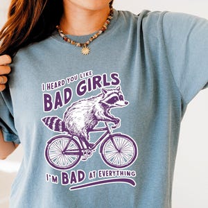 Ouvi dizer que você gosta de garotas más em tudo ruim camiseta, camiseta engraçada de guaxinim, camiseta de meme de guaxinim, camiseta de gambá, ditado sarcástico, camiseta retrô dos anos 90