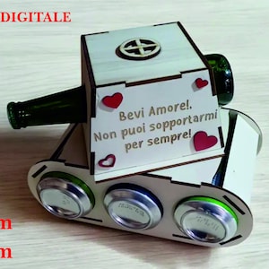 Può includere: Una scatola di legno a forma di carro armato con un messaggio che recita "Bevi Amore! Non puoi sopportarmi per sempre!" La scatola ha quattro slot per contenere lattine o bottiglie. La scatola è dipinta di bianco e ha un design a forma di cuore rosso.