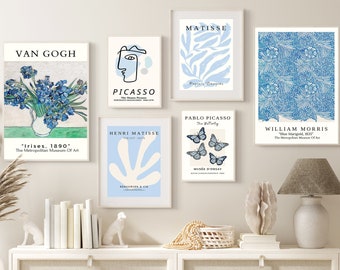 Op de afbeelding: Een verzameling ingelijste kunstprints met werken van Van Gogh, Picasso en Matisse. De prints tonen bloemen-, abstracte en vlinderontwerpen in blauw en wit. De kunstwerken worden gepresenteerd op een witte kast.