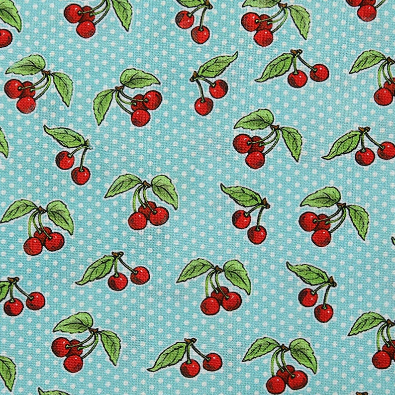 May include: A patterned fabric featuring red cherries with green leaves, set against a light blue backdrop dotted with white polka dots. The cherries are arranged in small clusters.