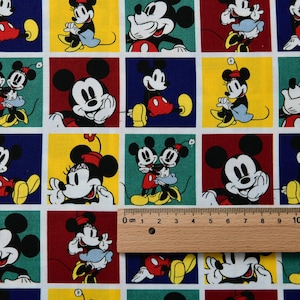 Könnte beinhalten: Stoff mit einem sich wiederholenden Muster von Mickey und Minnie Mouse in verschiedenen Posen. Die Quadrate sind in den Grundfarben Rot, Gelb, Blau und Grün gehalten. Die Charaktere sind in ihren klassischen Outfits mit schwarzen Umrissen und weißen Hintergründen dargestellt.