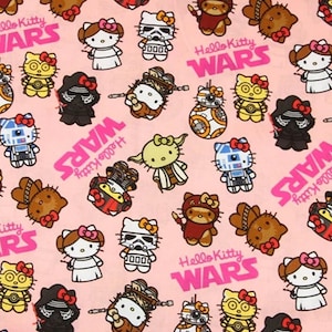 Pode incluir: Tecido rosa com um padrão repetido de personagens Hello Kitty vestidos como personagens de Star Wars. O design inclui personagens como Stormtroopers, Darth Vader e R2-D2, com as palavras "Hello Kitty WARS" em rosa.