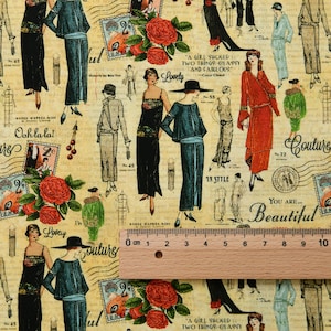 May include: A beige fabric featuring a vintage-style print of women in 1920s fashion, red roses, postage stamps, and cursive text, with a wooden ruler placed across the bottom showing measurements from 0 to 10 centimeters.