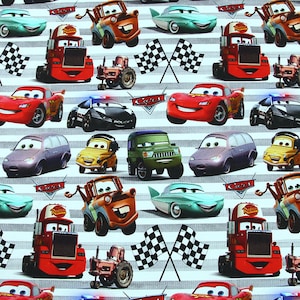 Könnte beinhalten: Ein weiß-grauer gestreifter Stoff mit einem sich wiederholenden Muster aus verschiedenen Cartoon-Autos aus dem Disney Pixar Film Cars. Die Autos beinhalten Lightning McQueen, Mater und andere Charaktere. Der Stoff zeigt auch karierte Flaggen.
