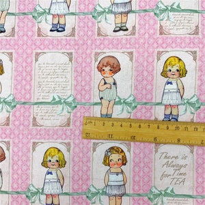 May include: Pink fabric with a repeating pattern of framed illustrations of children in vintage clothing. The illustrations are surrounded by green ribbons and the text "There is Always for Time TEA" is visible in the bottom right corner.