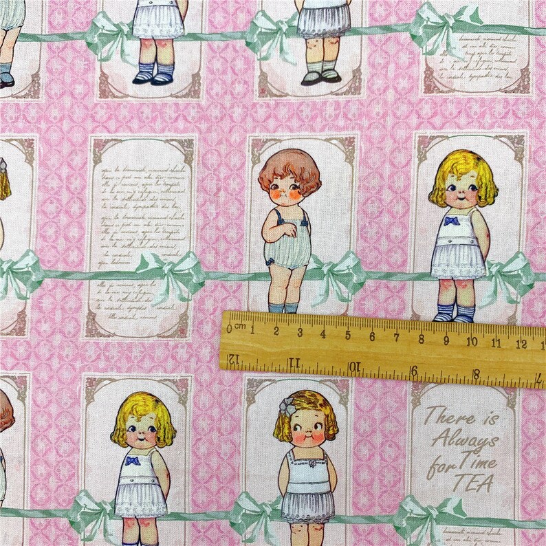 May include: Pink fabric with a repeating pattern of framed illustrations of children in vintage clothing. The illustrations are surrounded by green ribbons and the text "There is Always for Time TEA" is visible in the bottom right corner.