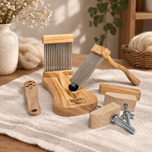 May include: A wooden wool carding tool set featuring a base with a vertical metal comb, a handheld carder with metal teeth, and various wooden components including a handle and hardware. The base is branded with the text UNCLE KOLYA.