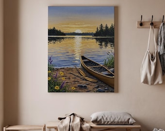 May include: A canvas print of a serene lake scene at sunset. A wooden canoe and paddles rest on the shore. The water reflects the golden light of the setting sun, with trees silhouetted on the horizon. Wildflowers dot the shoreline.