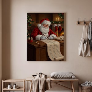 May include: A canvas print depicts Santa Claus writing on a long scroll labeled "Nice List." He wears a red suit and hat, with a white beard. A Christmas tree and fireplace are in the background. The print is displayed on a wall with a coat rack.