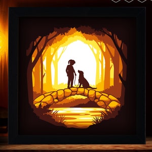 Könnte beinhalten: Eine Silhouette einer Person, die einen Hund auf einer Brücke in einem Wald spazieren führt. Die Szene ist in einem warmen, orangenen Licht gehalten. Das Bild ist ein Papier-Schnitt-Design.