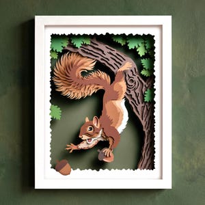 Peut inclure: Une œuvre d'art en papier superposé dans un cadre blanc représentant un écureuil brun suspendu à une branche d'arbre avec des feuilles vertes. L'écureuil a une grande queue touffue et tient un gland, tandis qu'un autre gland tombe en dessous.
