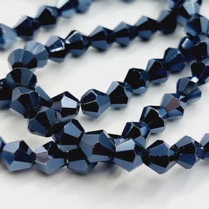 May include: A strand of dark blue faceted glass beads. The beads are arranged in a circular pattern, creating a layered effect.