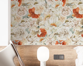 Pode incluir: Papel de parede com um padrão floral denso de flores brancas, creme e laranja queimado. O design cobre uma parede acima de uma cabeceira de madeira num quarto que inclui uma cadeira branca, um candeeiro de pé preto e uma cama com roupa de cama branca.