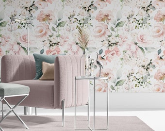 May include: A dusty pink channel-tufted armchair with a matching ottoman featuring a light gray upholstered seat and a silver X-shaped metal base. A slim silver side table holds a glass vase with a dried palm leaf and a small bird figurine.