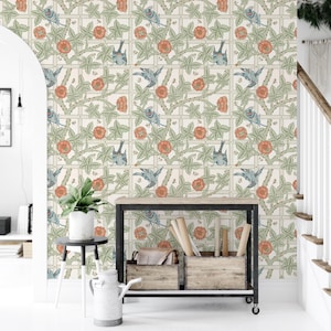 Peut inclure: Papier peint avec un motif répétitif d'oiseaux bleus, de fleurs orange et de feuilles vertes sur un fond crème. Le motif est encadré dans une grille, créant une esthétique vintage structurée. Le papier peint est affiché sur un mur.