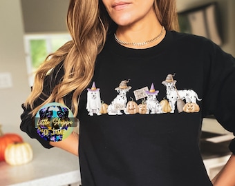 May include: Black sweatshirt with a graphic of six Dalmatian dogs dressed in Halloween costumes. The dogs are holding pumpkins and signs that say "Boo" and "Trick or Treat".