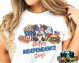 May include: White t-shirt with a cartoon dog wearing sunglasses and holding a hot dog, popcorn, ice cream cone, and hamburger. The text "Happy Independence Day!" is printed below the dog.