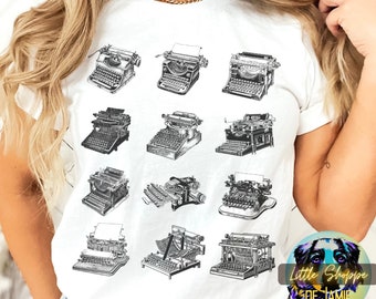 May include: White t-shirt with a black and white graphic of vintage typewriters. The graphic features 12 different typewriters in a grid pattern.