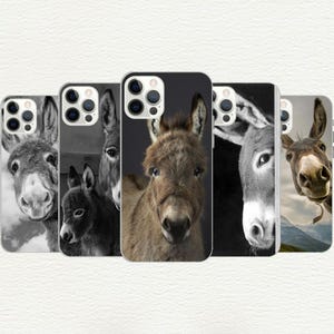 May include: Five different phone cases featuring a donkey design. The cases are black, white and brown. The donkeys are all different colours and have different expressions.