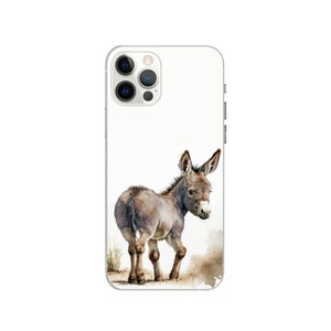 Puede incluir: Una funda de smartphone blanca con una ilustraci&oacute;n en acuarela de un peque&ntilde;o burro gris de pie sobre un trozo de tierra marr&oacute;n. El burro est&aacute; situado en la parte inferior central, mirando por encima del hombro con las orejas hacia arriba.