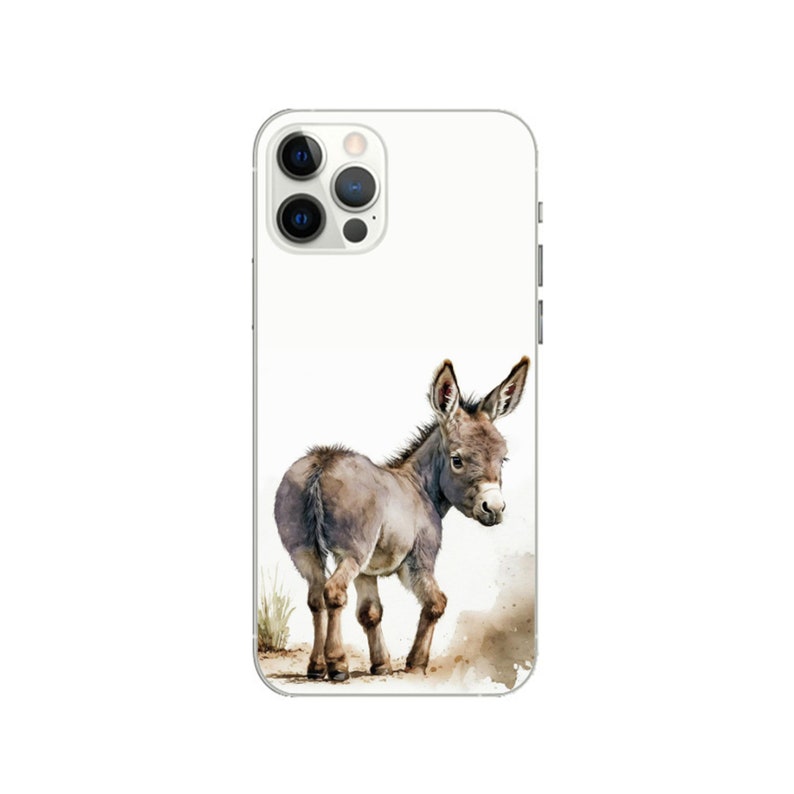 Puede incluir: Una funda de smartphone blanca con una ilustraci&oacute;n en acuarela de un peque&ntilde;o burro gris de pie sobre un trozo de tierra marr&oacute;n. El burro est&aacute; situado en la parte inferior central, mirando por encima del hombro con las orejas hacia arriba.