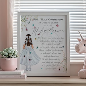 May include: A framed First Holy Communion print with the name "Marlow Emerson" and a poem, featuring a girl illustration with butterflies. A pink unicorn plush toy and a succulent in a pink pot are also visible.