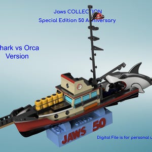 May include: A detailed model of a boat with a shark attached, part of the Jaws Collection. The boat is red, black, and beige, with a mast and a shark figure. The base reads "JAWS 50". The text "Shark vs Orca Version" is also visible.