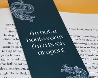 May include: A dark blue bookmark with a white dragon design and the text "I'm not a bookworm, I'm a book dragon!"