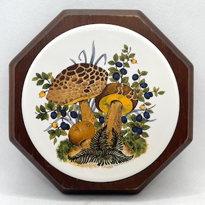 tuile ronde en céramique vintage de champignon sur le dessous de plat octogonal en bois, tenture murale