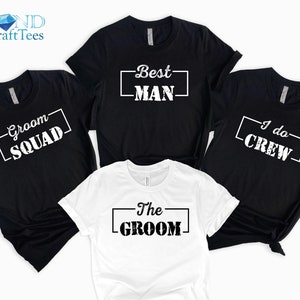 May include: Four black t-shirts with white text and one white t-shirt with black text. The shirts say "Groom Squad", "Best Man", "I do Crew", "The Groom".