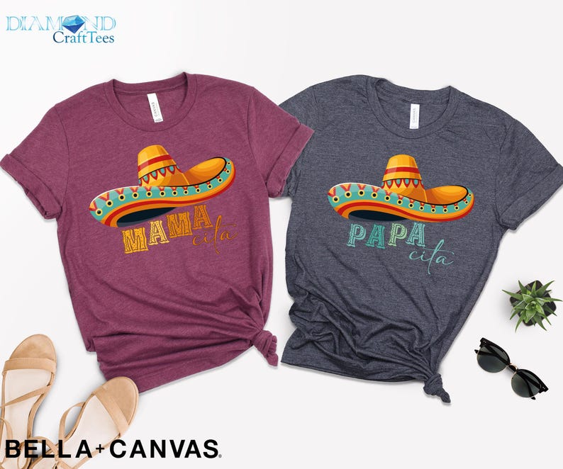 Puede incluir: Dos camisetas con un dise&ntilde;o de sombrero colorido y texto. La camiseta granate dice "Mamacita" y la camiseta azul dice "Papa cita".