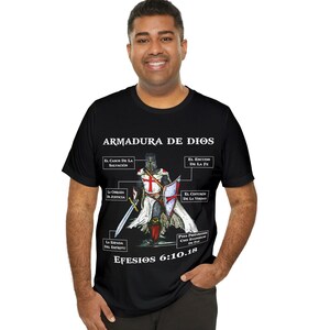 May include: Black t-shirt with a graphic of a knight in armor and the text "ARMADURA DE DIOS" and "EFESIOS 6:10.18".