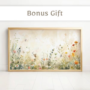 May include: A framed watercolor painting of a field of wildflowers with butterflies. The painting is in a light wood frame and has a soft, dreamy feel.