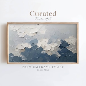 May include: Abstract painting in shades of blue and white, framed in a light wood frame. The painting depicts a textured landscape with clouds. The text "Curated Frame Art" and "PREMIUM FRAME TV ART 3840x2160" is visible below the painting.