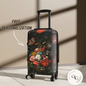 Könnte beinhalten: Ein schwarzer Koffer mit einem Blumenmuster, das einen Strauß roter, orangefarbener, gelber und blauer Blumen zeigt. Der Koffer hat einen schwarzen Griff und vier Räder. Der Text "FREE PERSONALIZATION" ist auf dem Bild zu sehen.