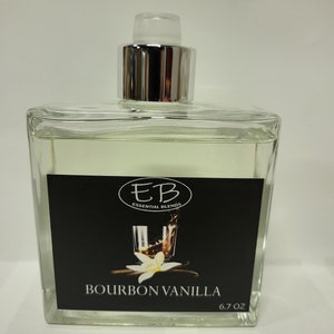 May include: A clear glass bottle with a silver cap and a black label. The label has a white circle with the letters "EB" and the text "Essential Blends". The label also has a drawing of a glass of bourbon with a vanilla bean. The text "Bourbon Vanilla" and "6.7 oz" are on the label.
