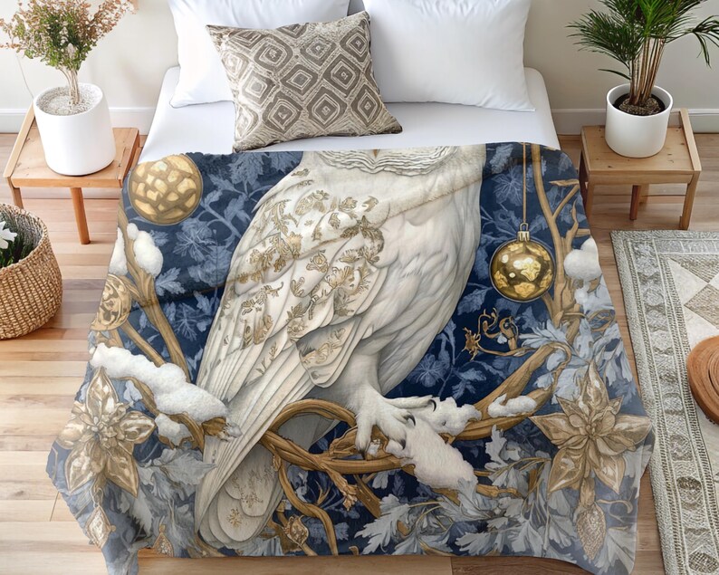 May include: A white owl with gold accents sits on a branch with gold ornaments and blue and white floral designs. The owl is perched on a branch with snow-covered branches and leaves.