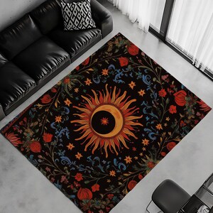 May include: A black and gold rug with a floral pattern and a large sun and moon design in the center. The rug has a dark background with bright colors and intricate details.