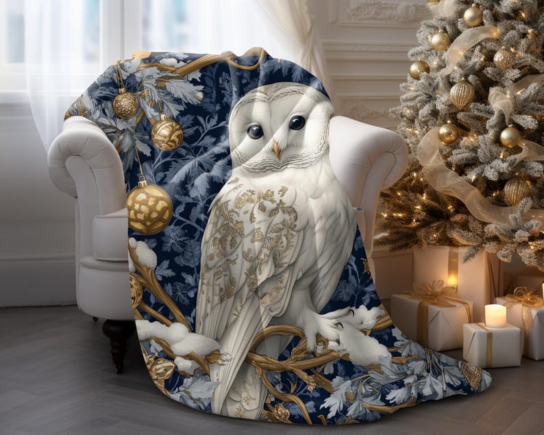 May include: A blue and white throw blanket with a snowy owl design. The owl is perched on a branch with gold ornaments and snowflakes.