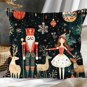 May include: A Christmas-themed throw pillow with a dark green background featuring a nutcracker, a ballerina, and two reindeer. The nutcracker is wearing a red and gold uniform, and the ballerina is wearing a white dress with red accents. The reindeer are brown and white.