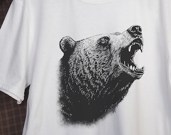 May include: White t-shirt with a black and white illustration of a bear roaring. The bear is facing right and has a detailed design.