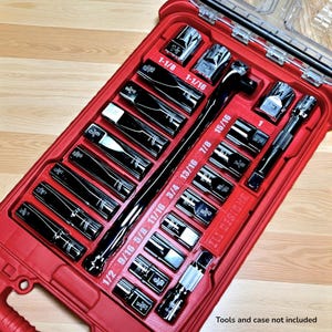 May include: A red toolbox with a clear lid, filled with a set of black sockets and wrenches. The sockets are labeled with sizes like 1/2, 5/8, and 3/4 inches. The text "ZLI DESIGNS" is visible on the case. The text "Tools and case not included" is also visible.