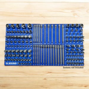 Puede incluir: Un organizador de herramientas azul con varios enchufes y extensiones. El organizador tiene múltiples compartimentos con tamaños en pulgadas. El texto "ZLL DESIGNS" es visible. El texto "Sockets not included" también es visible.