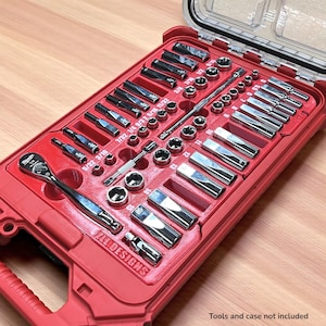 Può includere: Un organizer per utensili rosso pieno di varie prese, cricchetti ed estensioni argentate. L'organizer ha un coperchio trasparente ed è etichettato con misure in pollici. Il testo "ZAL DESIGNS" è visibile.