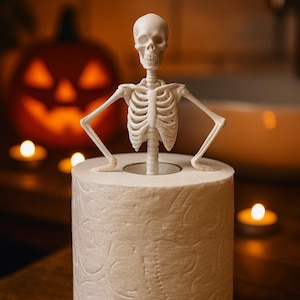 May include: A white skeleton figure perched atop a roll of toilet paper. The skeleton is a Halloween decoration. A carved pumpkin and lit candles are in the background, creating a spooky atmosphere.