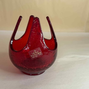 Pode incluir: Uma tigela de vidro Viking vermelho rubi com acabamento craquelado. A tigela tem uma base arredondada e três alças arqueadas. Uma etiqueta Viking é afixada na frente. Feito à mão nos EUA.
