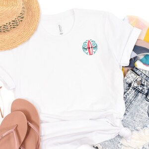 May include: White t-shirt with a graphic of a surfboard and the text "Chasing Waves" in a circle.