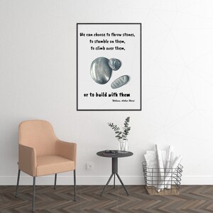 May include: A black and white inspirational quote with a watercolour illustration of three stones. The quote reads "We can choose to throw stones, to stumble on them, to climb over them, or to build with them." - William Arthur Ward